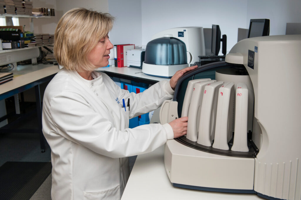 Lab technician looking at machine in pathology lab, new southern general hospital, Glasgow
